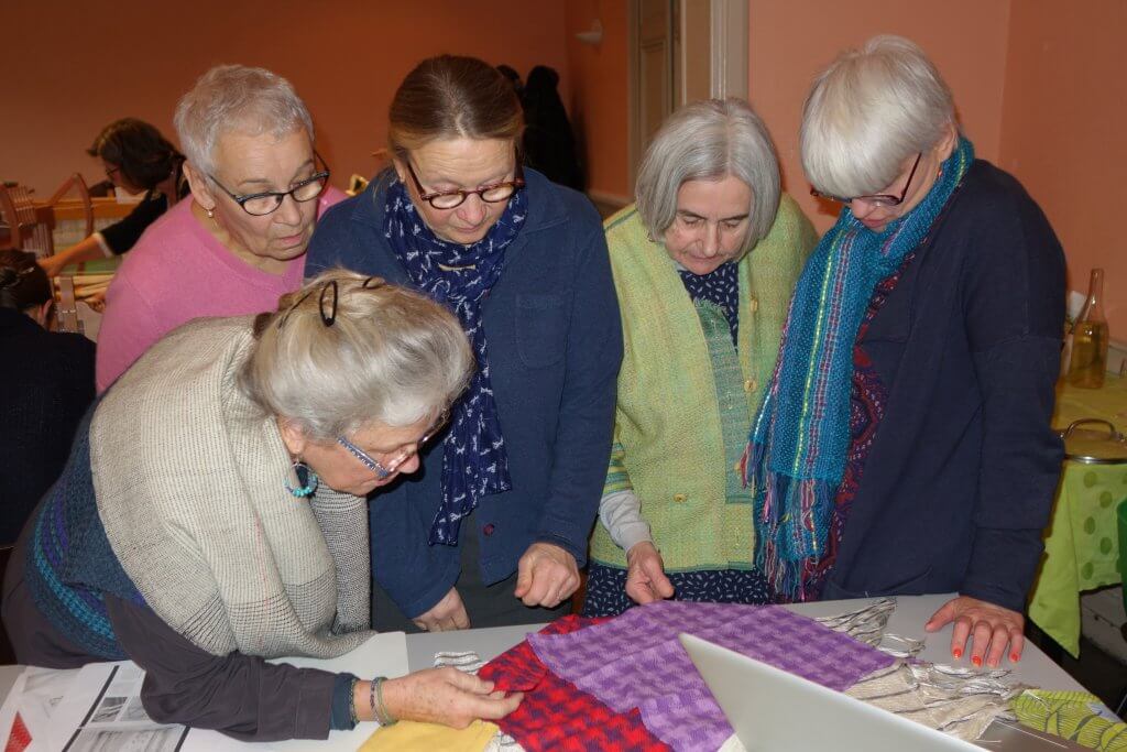 Les tissages de chacun exposés sur une grande table